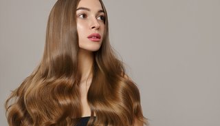 Młoda kobieta z falowanymi włosami i makijażem na twarzy