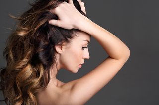 Kobieta przeczesująca swoje długie brązowe włosy