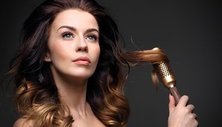 Kobieta o długich i lśniących włosach ombre ze szczotką do stylizacji włosów