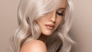 Piękna uśmiechnięta blond modelka z długimi blond włosami.