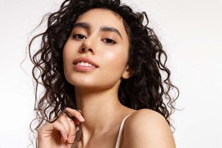 Młoda kobieta z kręconymi włosami i zadbaną cerą