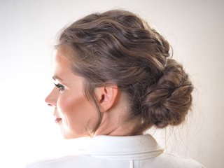 Młoda kobieta z włosami upiętymi w niski kok widziana od boku