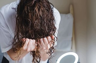 Ugniatanie mokrych kręconych włosów dłońmi z głową w dół