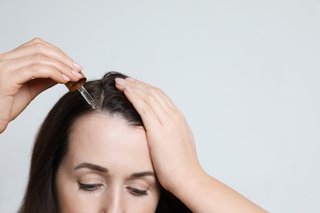 Młoda kobieta aplikuje serum na porost włosów