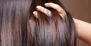 zbliżenie na kobiecą dłoń przeczesującą lśniące włosy