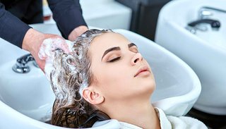 Kobieta podczas pielęgnacji włosów u fryzjera