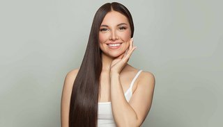 uśmiechnięta kobieta o długich, gładkich, nawilżonych włosach